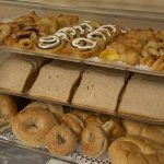 breakfast buffet setup with pastries, breads and bagels