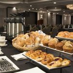 meeting room breakfast setup with pastries, coffee and bagels