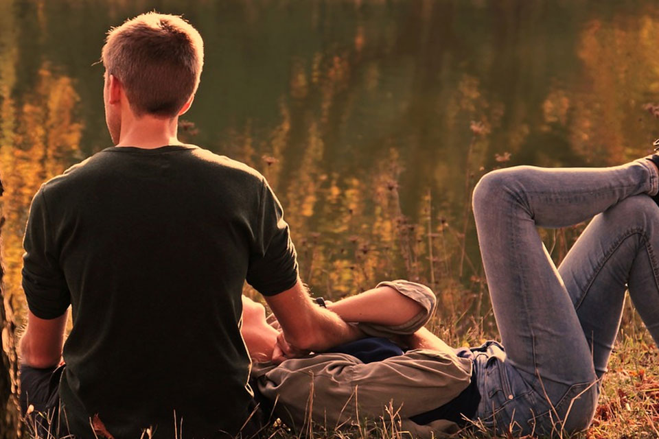 couple laying down in a field of flowers