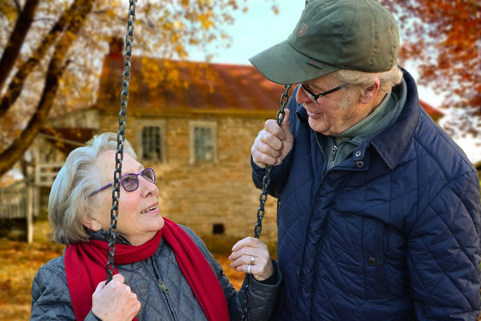 elderly couple on swing set